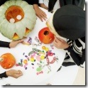 high-angle-view-group-children-sorting-candy-beside-carved-pumpkin